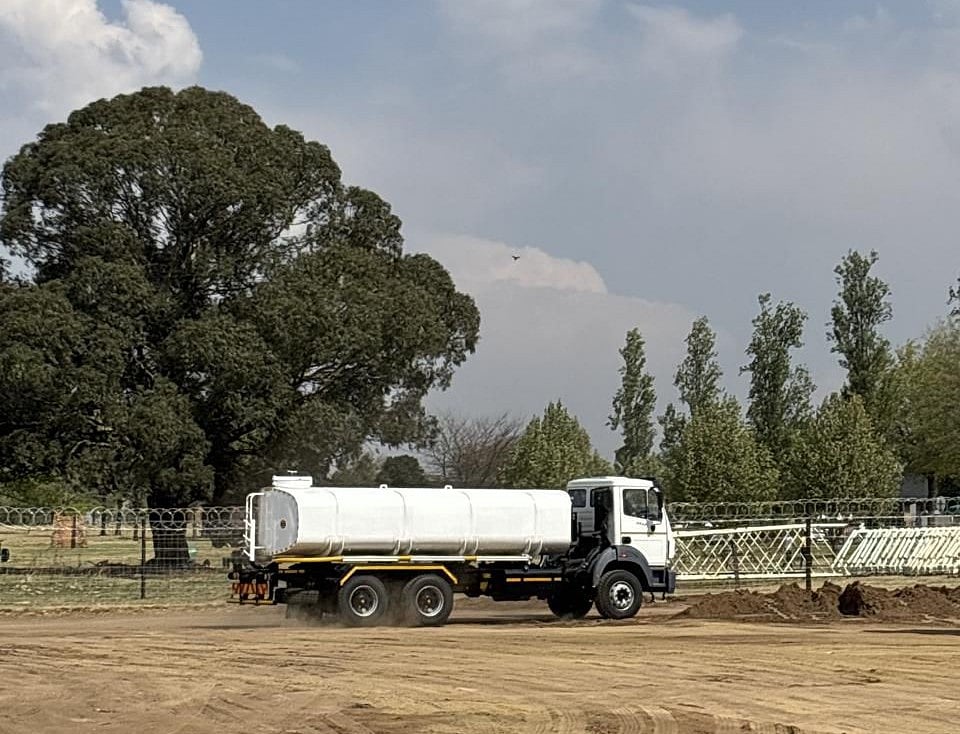 Aquafleet water truck in motion on a dusty site, performing dust suppression